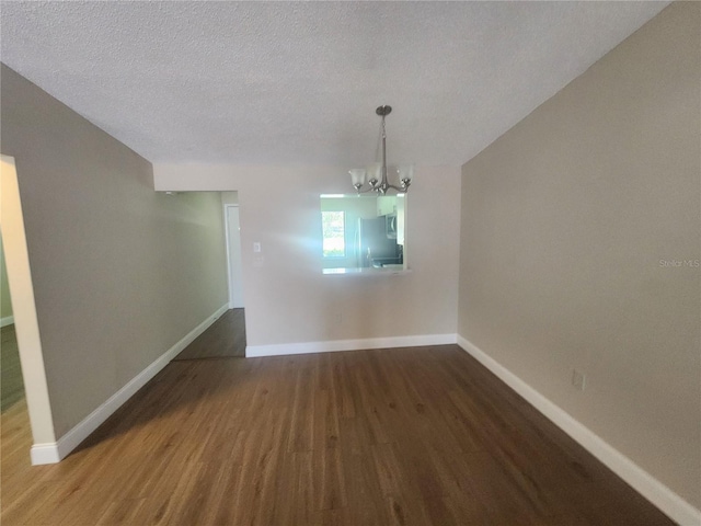 209 Corkwood Ln, Oldsmar, FL 34677 - unfurnished dining area with wood finished floors, a chandelier, and a textured ceiling