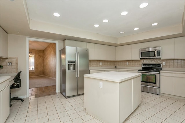 3262 Westcott Ct, Palm Harbor, FL 34684 - kitchen with appliances with stainless steel finishes, light countertops, a tray ceiling, light tile patterned floors, and tasteful backsplash