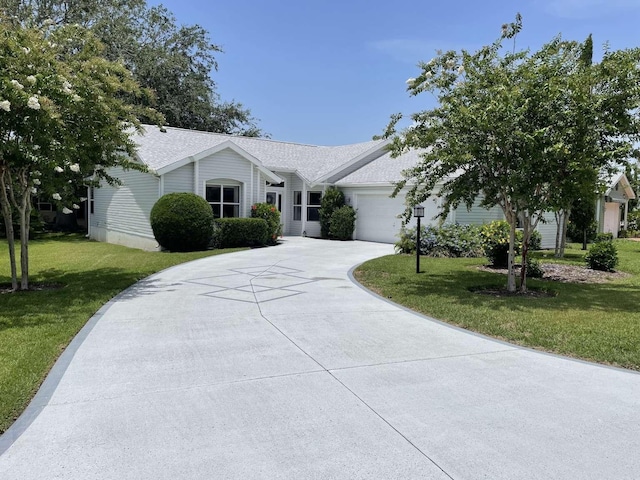 508 Alcazar Ct, Lady Lake, FL 32159 - ranch-style house with an attached garage, concrete driveway, a front yard, and roof with shingles
