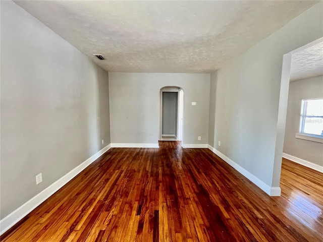3110 10th Ave N, Saint Petersburg, FL 33713 - unfurnished room with arched walkways, dark wood-style flooring, and a textured ceiling