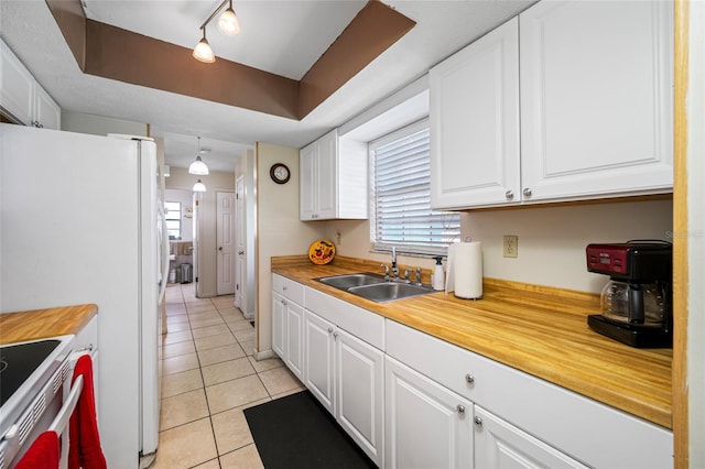 5107 Pine St, Seffner, FL 33584 - kitchen with light tile patterned floors, white cabinetry, white appliances, and rail lighting