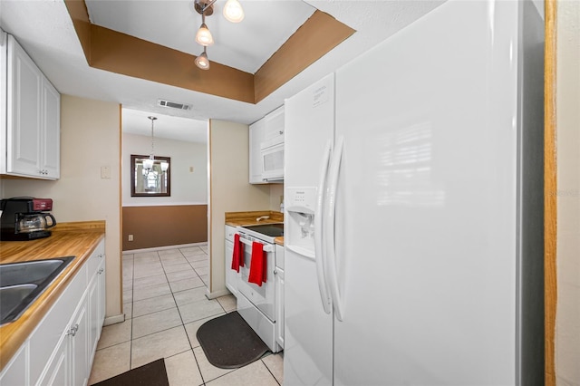 5107 Pine St, Seffner, FL 33584 - kitchen featuring white appliances, white cabinets, light tile patterned flooring, light countertops, and a tray ceiling