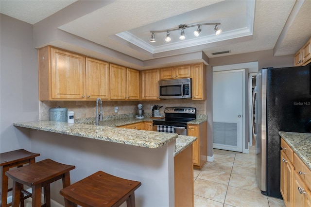 5340 Cobblestone Ct, Wesley Chapel, FL 33543 - kitchen with appliances with stainless steel finishes, a raised ceiling, tasteful backsplash, a peninsula, and a breakfast bar