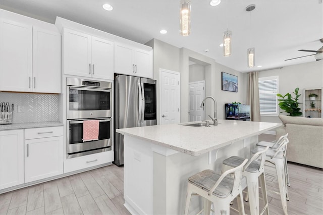 12382 Tibbetts St, Odessa, FL 33556 - kitchen with stainless steel appliances, open floor plan, light stone countertops, recessed lighting, and white cabinets