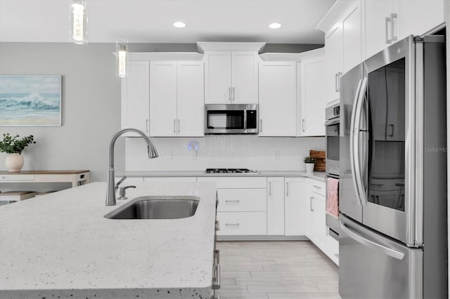 12382 Tibbetts St, Odessa, FL 33556 - kitchen featuring appliances with stainless steel finishes, white cabinetry, backsplash, hanging light fixtures, and recessed lighting