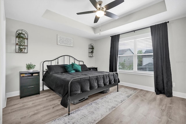 12382 Tibbetts St, Odessa, FL 33556 - bedroom featuring a raised ceiling, light wood-style floors, and ceiling fan