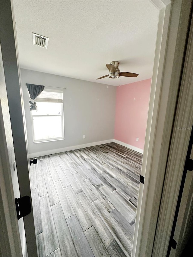 19743 Ellendale Dr, Land O Lakes, FL 34638 - empty room with wood finished floors, a ceiling fan, and a textured ceiling