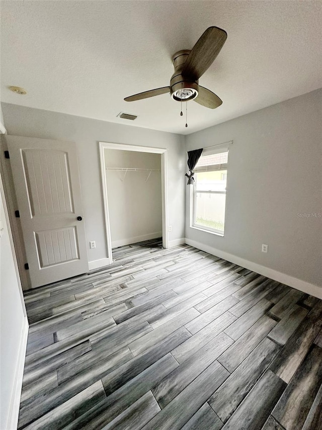 19743 Ellendale Dr, Land O Lakes, FL 34638 - unfurnished bedroom with a closet, light wood-style floors, ceiling fan, and a textured ceiling