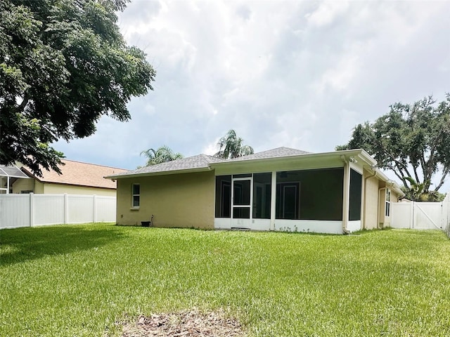 19743 Ellendale Dr, Land O Lakes, FL 34638 - back of property featuring a sunroom, stucco siding, a fenced backyard, and roof with shingles