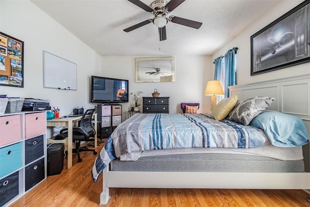 1304 Cedar Ct, Tarpon Springs, FL 34689 - bedroom with light wood finished floors, a textured ceiling, an office area, and a ceiling fan