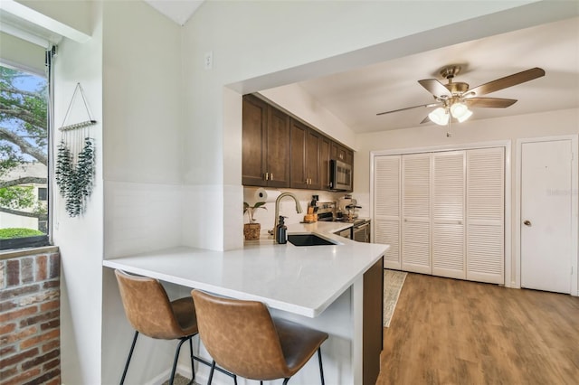 4114 Pinelake Ln Unit 202, Tampa, FL 33618 - kitchen with stainless steel appliances, light countertops, dark brown cabinets, a breakfast bar area, and ceiling fan