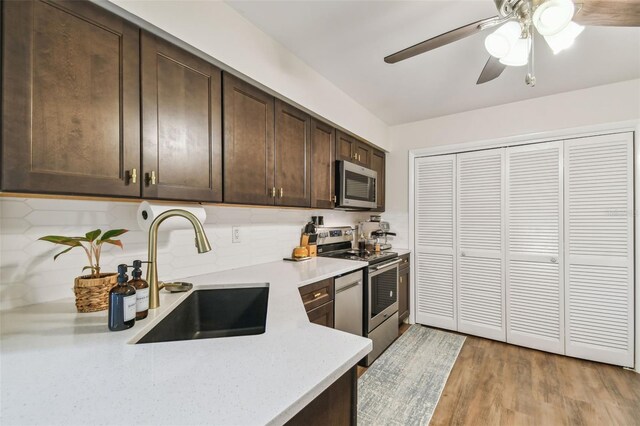 4114 Pinelake Ln Unit 202, Tampa, FL 33618 - kitchen featuring appliances with stainless steel finishes, dark brown cabinetry, light countertops, ceiling fan, and decorative backsplash