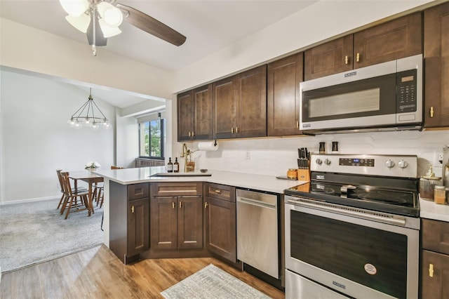 4114 Pinelake Ln Unit 202, Tampa, FL 33618 - kitchen featuring stainless steel appliances, light countertops, dark brown cabinets, a ceiling fan, and a peninsula