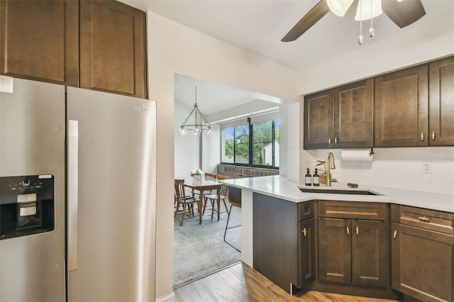 4114 Pinelake Ln Unit 202, Tampa, FL 33618 - kitchen with stainless steel fridge, light countertops, dark brown cabinetry, ceiling fan, and light wood-type flooring