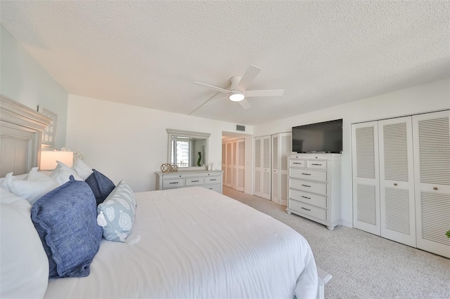 1591 Gulf Blvd Unit 304S, Clearwater Beach, FL 33767 - bedroom featuring multiple closets, a textured ceiling, light colored carpet, and ceiling fan