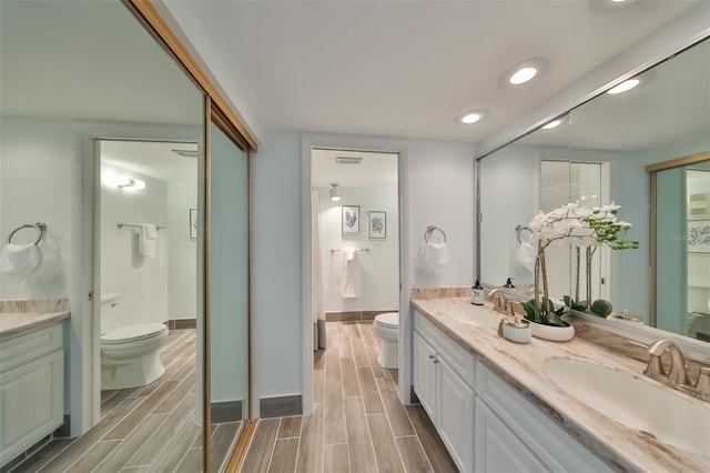 1591 Gulf Blvd Unit 304S, Clearwater Beach, FL 33767 - bathroom featuring double vanity, wood tiled floors, and recessed lighting