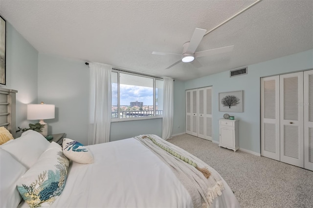 1591 Gulf Blvd Unit 304S, Clearwater Beach, FL 33767 - carpeted bedroom with multiple closets, a textured ceiling, and a ceiling fan