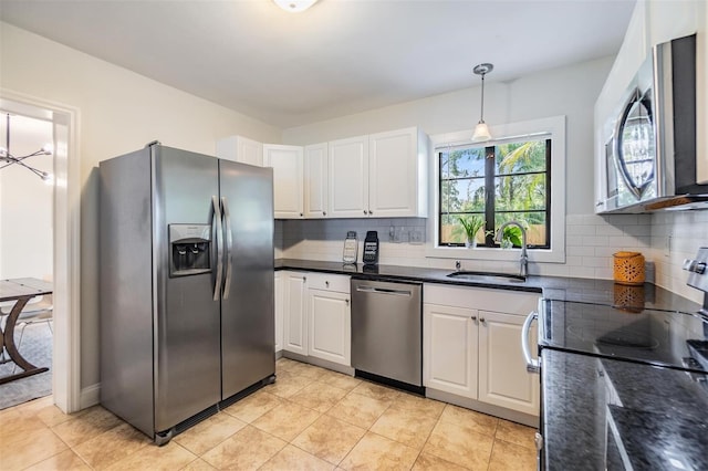 201 W Alva St, Tampa, FL 33603 - kitchen with stainless steel appliances, white cabinetry, decorative backsplash, hanging light fixtures, and light tile patterned floors