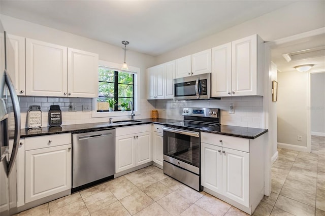 201 W Alva St, Tampa, FL 33603 - kitchen with appliances with stainless steel finishes, white cabinetry, decorative backsplash, and hanging light fixtures