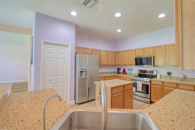 2228 Hannah Way S, Dunedin, FL 34698 - kitchen with stainless steel appliances, recessed lighting, light wood-style flooring, light brown cabinetry, and a center island