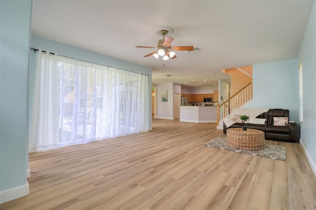 2228 Hannah Way S, Dunedin, FL 34698 - living room featuring ceiling fan, light wood-style flooring, and stairs