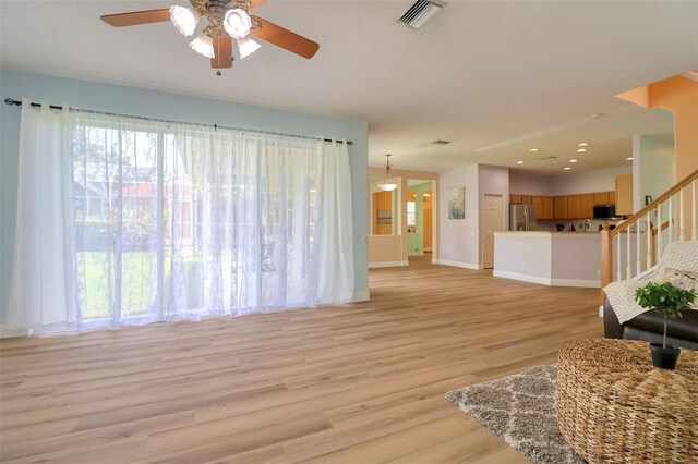 2228 Hannah Way S, Dunedin, FL 34698 - living area with ceiling fan, light wood-type flooring, and stairs