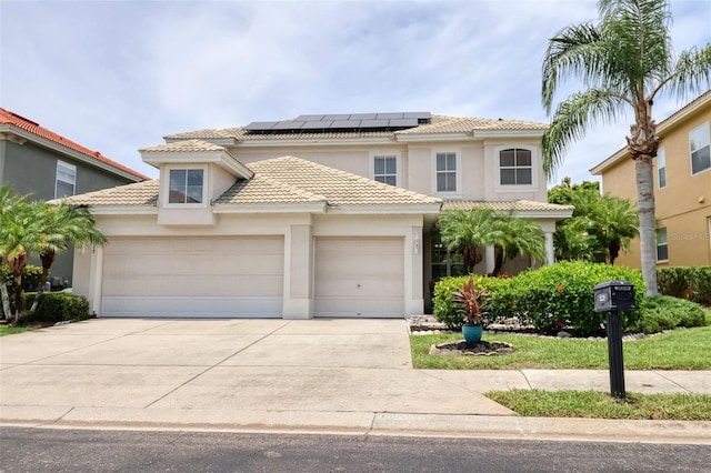 2228 Hannah Way S, Dunedin, FL 34698 - mediterranean / spanish-style house featuring an attached garage, stucco siding, concrete driveway, solar panels, and a tiled roof