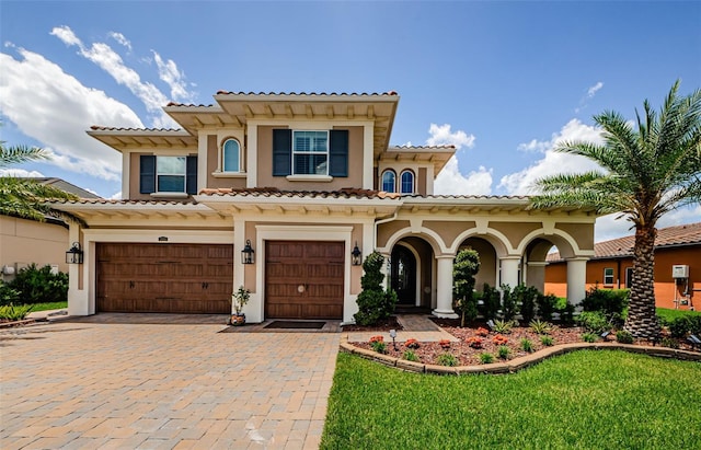 29038 Picana Ln, Wesley Chapel, FL 33543 - mediterranean / spanish-style house featuring an attached garage, stucco siding, decorative driveway, and a tile roof