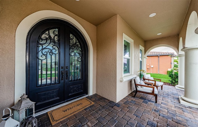 29038 Picana Ln, Wesley Chapel, FL 33543 - property entrance featuring french doors, stucco siding, and a porch