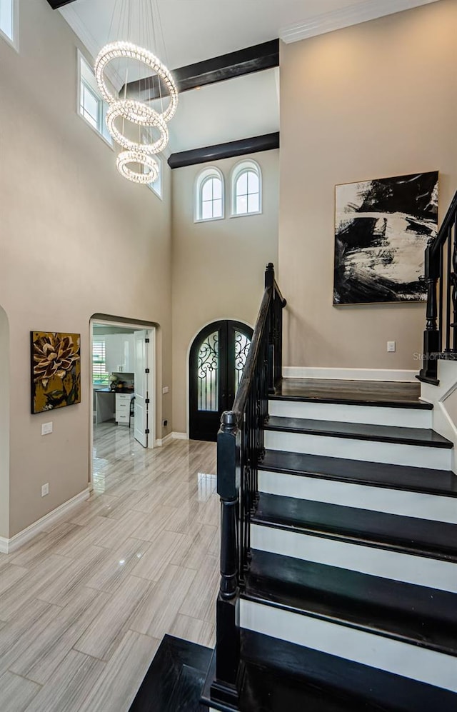 29038 Picana Ln, Wesley Chapel, FL 33543 - stairs featuring a chandelier, crown molding, a towering ceiling, healthy amount of natural light, and arched walkways