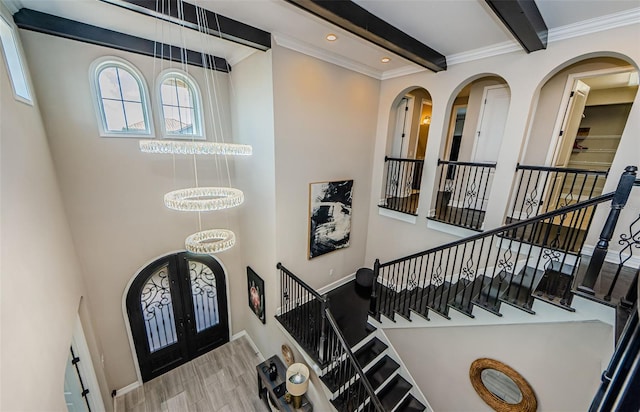 29038 Picana Ln, Wesley Chapel, FL 33543 - foyer with french doors, arched walkways, beamed ceiling, a high ceiling, and wood finished floors