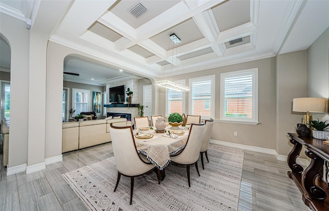 29038 Picana Ln, Wesley Chapel, FL 33543 - dining room featuring arched walkways, plenty of natural light, coffered ceiling, a large fireplace, and crown molding