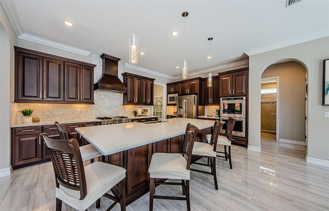 29038 Picana Ln, Wesley Chapel, FL 33543 - kitchen featuring custom exhaust hood, appliances with stainless steel finishes, arched walkways, a kitchen bar, and recessed lighting