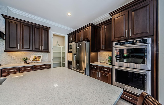 29038 Picana Ln, Wesley Chapel, FL 33543 - kitchen with stainless steel appliances, dark brown cabinets, backsplash, ornamental molding, and recessed lighting