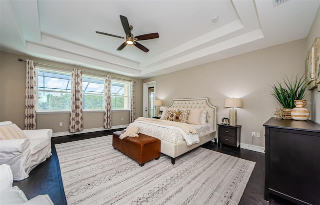 29038 Picana Ln, Wesley Chapel, FL 33543 - bedroom with a tray ceiling, dark wood finished floors, and ceiling fan
