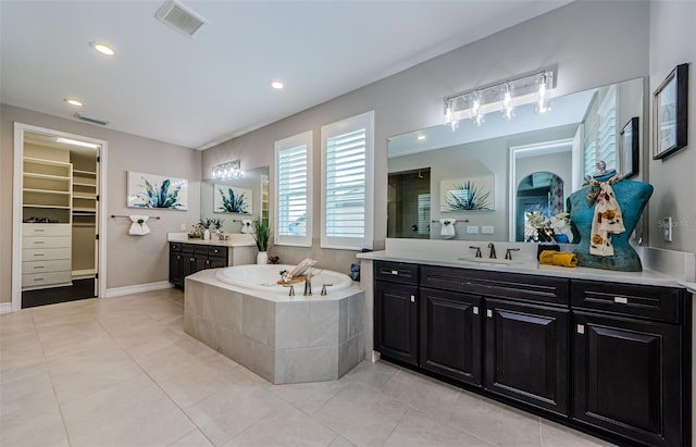 29038 Picana Ln, Wesley Chapel, FL 33543 - bathroom with two vanities, a bath, tile patterned floors, a spacious closet, and recessed lighting