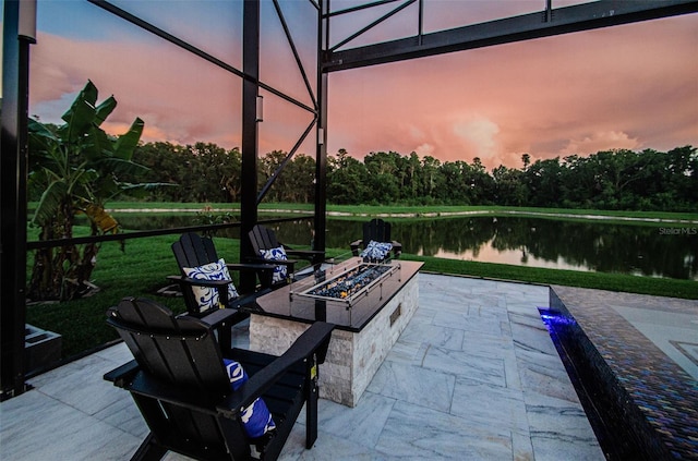 29038 Picana Ln, Wesley Chapel, FL 33543 - patio terrace at dusk with a fire pit, a water view, a patio, and view of wooded area