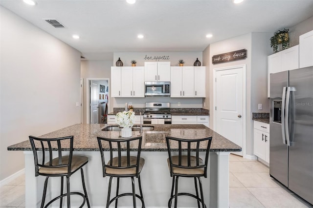 9839 Lemon Drop Loop, Sun City Center, FL 33573 - kitchen with appliances with stainless steel finishes, a kitchen bar, white cabinets, a center island with sink, and recessed lighting