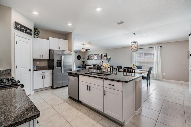 9839 Lemon Drop Loop, Sun City Center, FL 33573 - kitchen featuring stainless steel appliances, light tile patterned floors, white cabinetry, a center island with sink, and ceiling fan