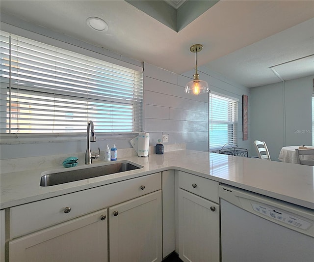 18650 Gulf Blvd Unit 314, Indian Shores, FL 33785 - kitchen featuring dishwasher, light countertops, white cabinets, decorative light fixtures, and a peninsula