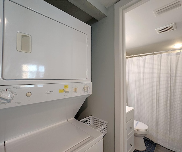 18650 Gulf Blvd Unit 314, Indian Shores, FL 33785 - washroom featuring estacked washer and dryer and dark tile patterned floors
