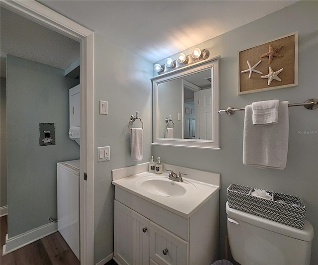18650 Gulf Blvd Unit 314, Indian Shores, FL 33785 - bathroom featuring stacked washing machine and dryer, vanity, and wood finished floors