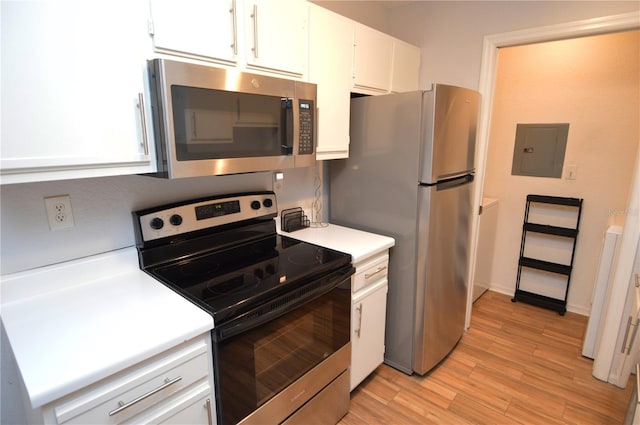 10265 Gandy Blvd N Unit 1409, Saint Petersburg, FL 33702 - kitchen featuring appliances with stainless steel finishes, electric panel, white cabinetry, light countertops, and light wood-type flooring
