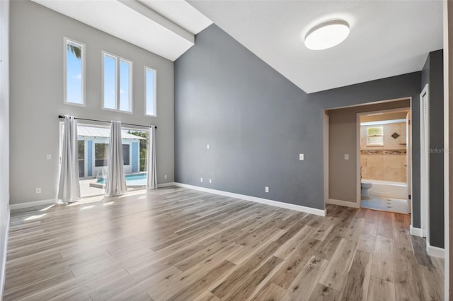 428 Klosterman Rd W, W, Palm Harbor, FL 34683 - empty room with light wood finished floors and high vaulted ceiling