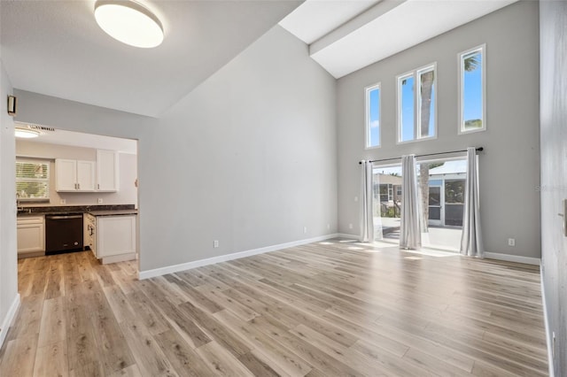 428 Klosterman Rd W, W, Palm Harbor, FL 34683 - unfurnished living room featuring high vaulted ceiling, light wood-style flooring, and healthy amount of natural light