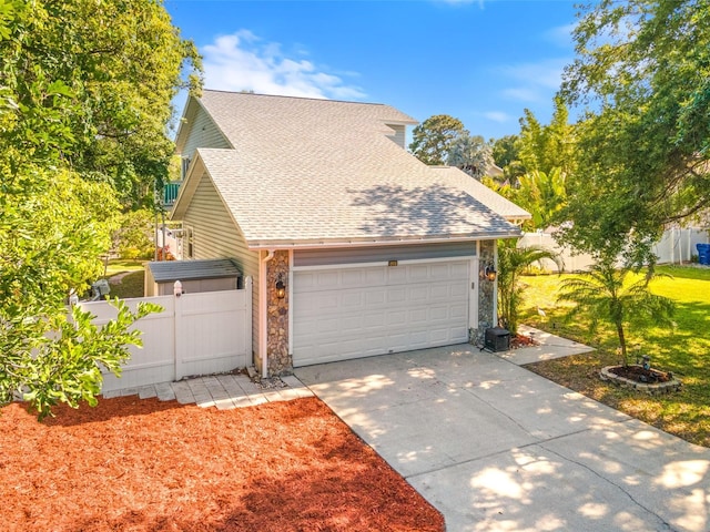 428 Klosterman Rd W, W, Palm Harbor, FL 34683 - view of front of house featuring stone siding, concrete driveway, a garage, and roof with shingles