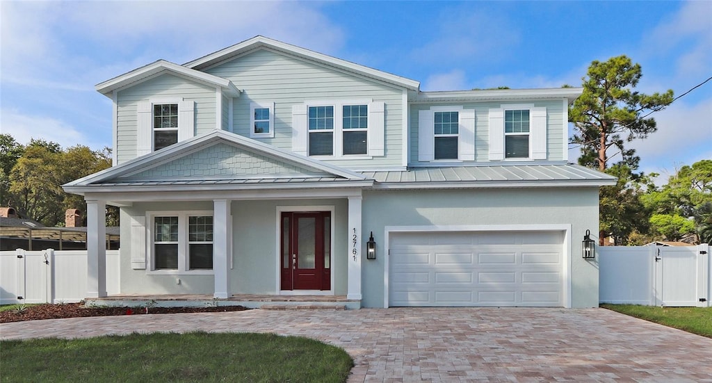 2700 Beach Blvd S, Gulfport, FL 33707 - view of front facade with a standing seam roof, an attached garage, decorative driveway, a metal roof, and a porch