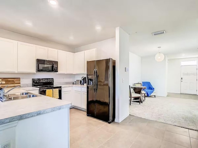 10024 Merry Fawn Ct, Sun City Center, FL 33573 - kitchen with black appliances, light countertops, white cabinets, pendant lighting, and recessed lighting