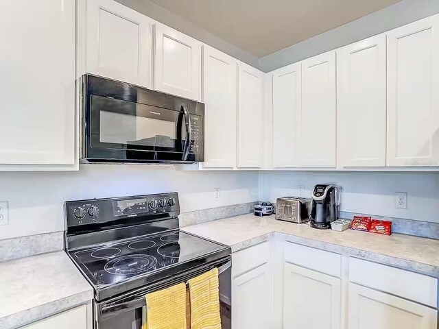 10024 Merry Fawn Ct, Sun City Center, FL 33573 - kitchen with black appliances, light countertops, and white cabinetry