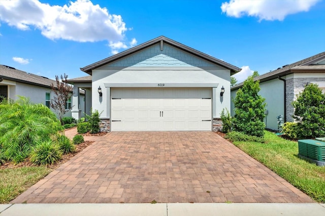 6019 Shorebird Br, Land O Lakes, FL 34638 - ranch-style house featuring stone siding, stucco siding, decorative driveway, and a garage